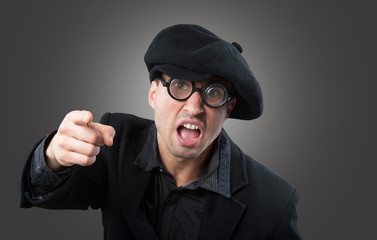 Angry man in a beret pointing at camera