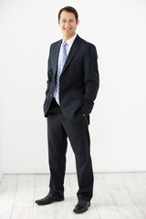 Studio Portrait Of Businessman Standing Against White Background