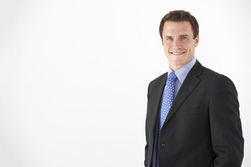 Studio Portrait Of Businessman Standing Against White Background