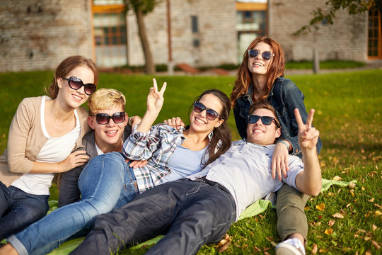 group of happy students showing victory gesture
