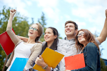 group of happy students showing triumph gesture