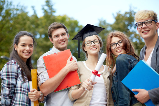 group of smiling students with diploma and folders