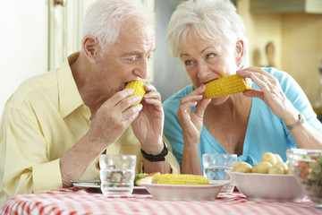 Senior Couple Eating Meal Together In Kitchen