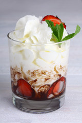 Healthy layered  desserts with fresh strawberries and cream on wooden 