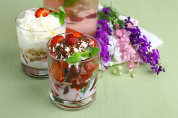 Healthy layered  desserts with fresh strawberries and cream on wooden 