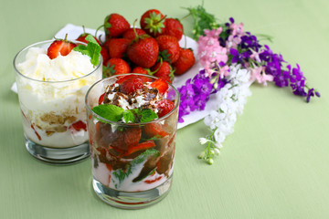 Healthy layered  desserts with fresh strawberries and cream on wooden 