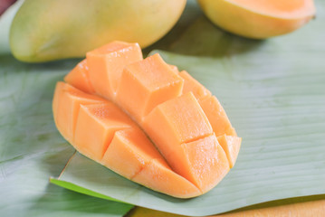 Ripe mango with slices on banana leaves