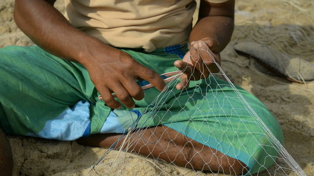 fisherman repairing net for fishing, Arugam bay, Sri Lanka, Asia