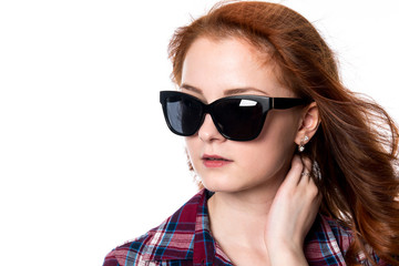 Close-up portrait of red-haired girl with sunglasses looking to