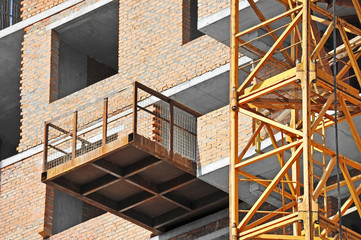 Crane and building construction site with balcony