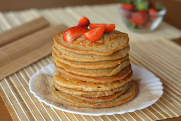 Stack of sweet pancakes with fresh strawberries and cinnamon sugar 