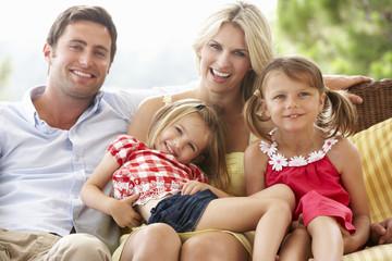 Family Sitting  On Garden Seat Together