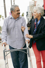 Wife Helping Senior Husband To Use Walking Frame