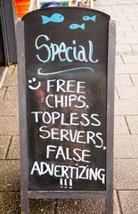 funny advertizing board in front of a pub