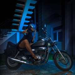 Biker girl sits on a chopper motorcycle