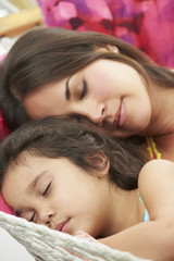 Obraz na płótnie Canvas Mother And Daughter Sleeping In Garden Hammock Together