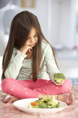 Unhappy Young Girl Rejecting Plate Of Fresh Vegetables