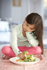 Unhappy Young Girl Rejecting Plate Of Fresh Vegetables