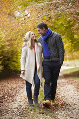 Couple Walking Along Autumn Path