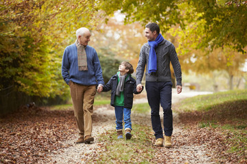 Male Multl Generation Family Walking Along Autumn Path