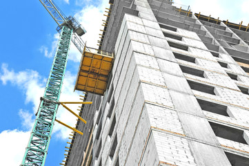 Fototapeta premium Crane and building construction site against blue sky