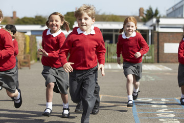 Elementary School Pupils Running In Playground