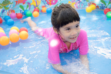 Fototapeta na wymiar Baby girl playing in kiddie pool