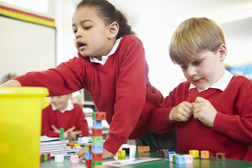 Pupils Working With Coloured Blocks In Maths Lesson