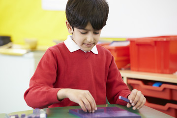 Male Pupil Practising Maths At Desk