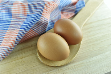 Two egg in wooden spoon on wooden background