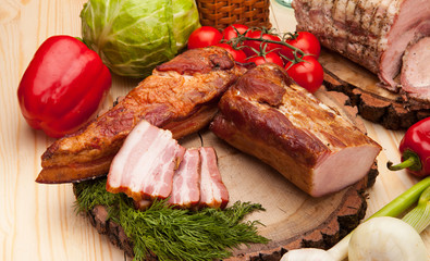 Smoked meat with bright summer vegetables on wooden background