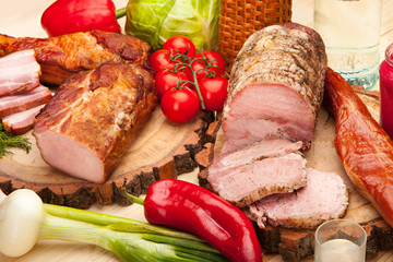 Smoked meat with bright summer vegetables on wooden background