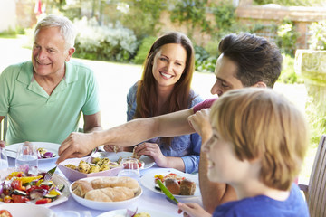Multi Generation Family Enjoying Outdoor Meal Together