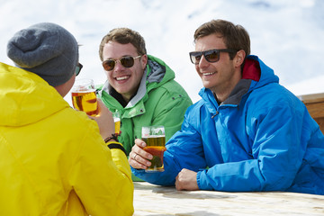 Group Of Young Men Enjoying Drink In Bar At Ski Resort