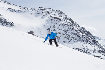 Fototapeta na wymiar Man Snowboarding On Ski Holiday In Mountains