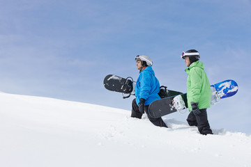 Fototapeta na wymiar Two Men With Snowboards On Ski Holiday In Mountains