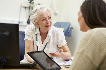 Fototapeta na wymiar Consultant Showing Patient Test Results On Digital Tablet