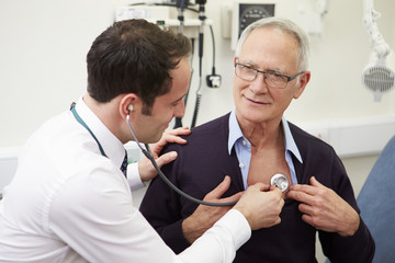Doctor Examining Senior Male Patient In Hospital