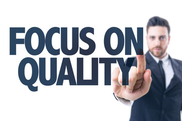 Business man pointing the text: Focus On Quality