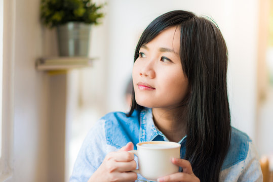 Beautiful cute girl in the cafe with white coffee cup