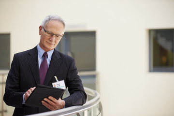 Male Consultant Using Digital Tablet In Hospital