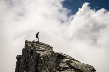 Hiker standing high up on rocky mountain peak © fabio lamanna