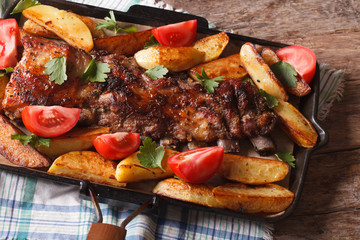 pork ribs, potatoes and tomatoes closeup. Horizontal top view
