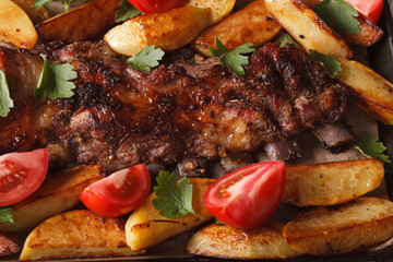 pork ribs, potatoes and tomatoes macro. horizontal top view
