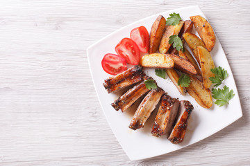 Grilled ribs, potatoes and tomatoes horizontal top view
