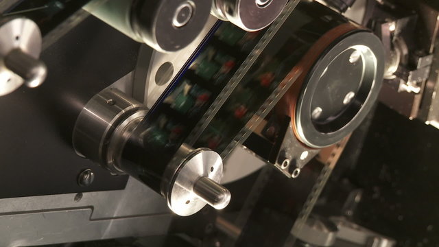 Detail of 35mm film moving through a telecine machine in a movie post production facility