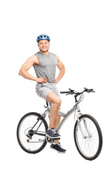 Young man posing seated on a bicycle