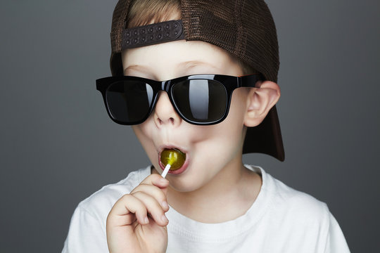 Funny Young Boy Eating A Lollipop.child in sunglasses