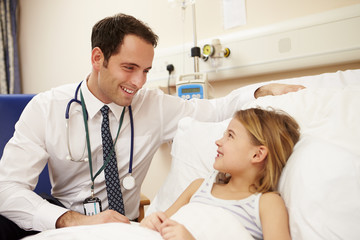 Fototapeta premium Doctor Sitting By Young Girl's Bed In Hospital