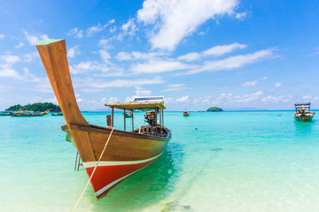 Fototapeta na wymiar Wood boat and islands in andaman sea against blue sky at Lipe